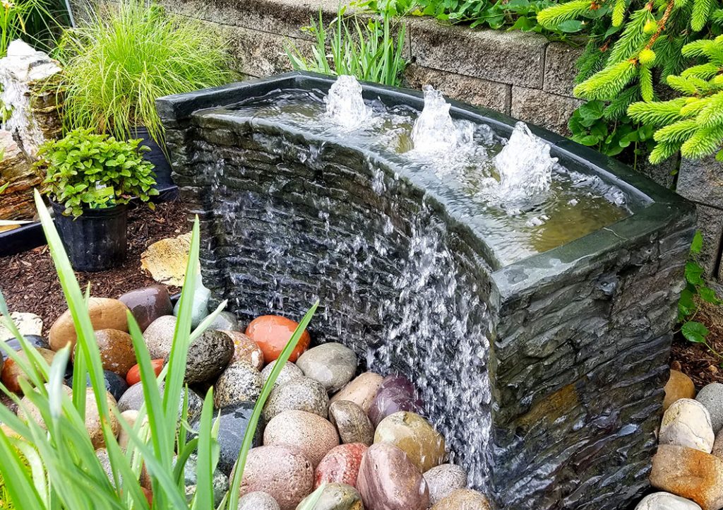 Garden fountain with flowing water and stones.