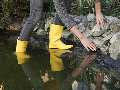 Person crossing stream in yellow boots.