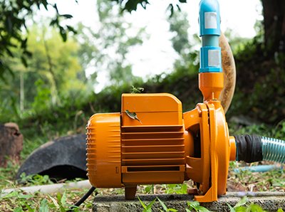 Orange water pump on grass outdoors