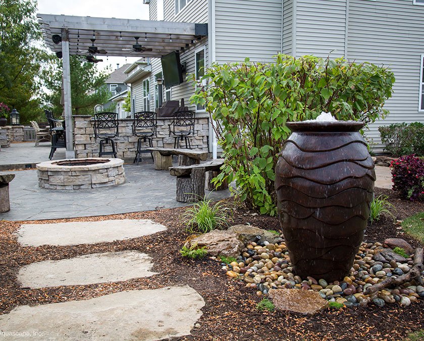 Backyard patio with fountain and seating area.