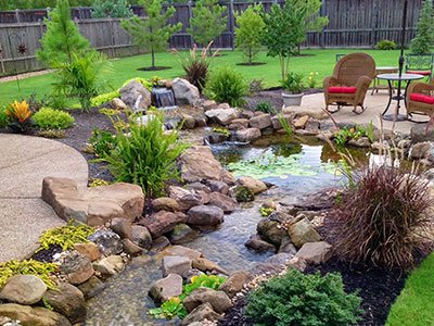 Tranquil backyard garden with waterfall and seating area.