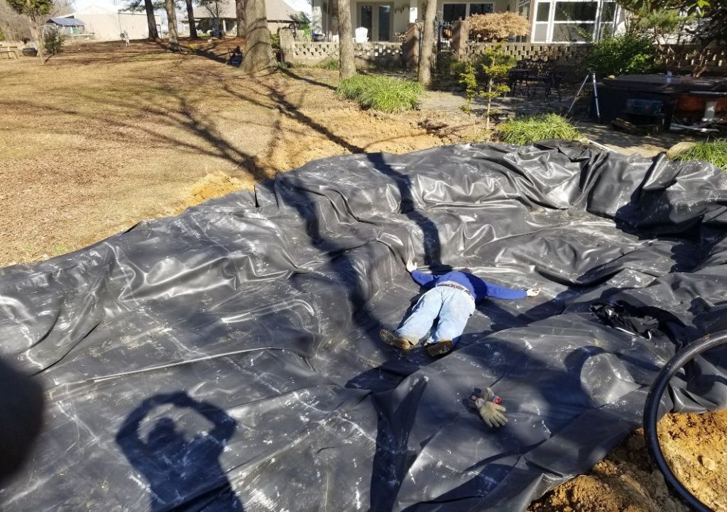 Laying liner as part of how to build a pond